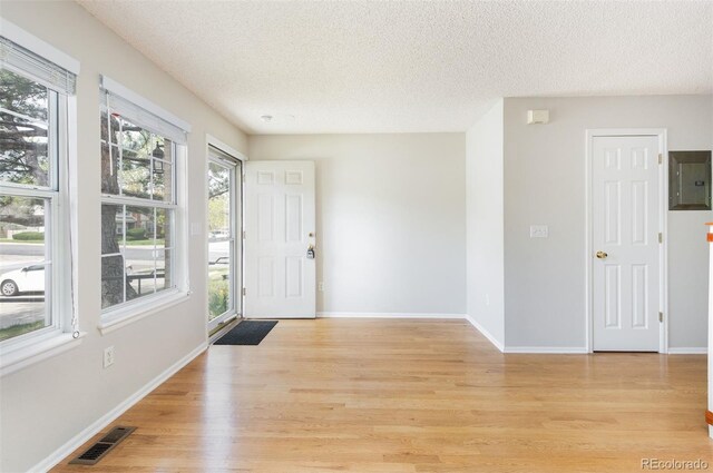 3098 W 107th Pl Unit C, Westminster, CO 80031 - foyer featuring electric panel, a textured ceiling, light wood finished floors, and baseboards