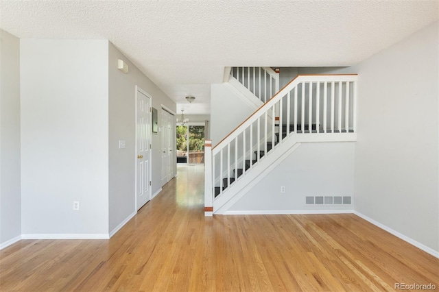 3098 W 107th Pl Unit C, Westminster, CO 80031 - foyer with stairs, light wood finished floors, baseboards, and a textured ceiling