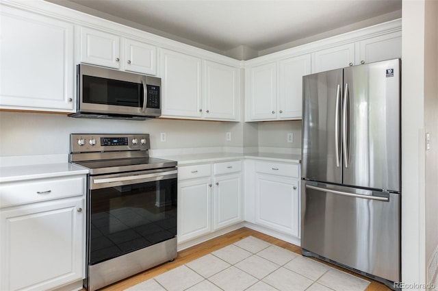 3098 W 107th Pl Unit C, Westminster, CO 80031 - kitchen with stainless steel appliances, white cabinets, light countertops, and light wood-style floors