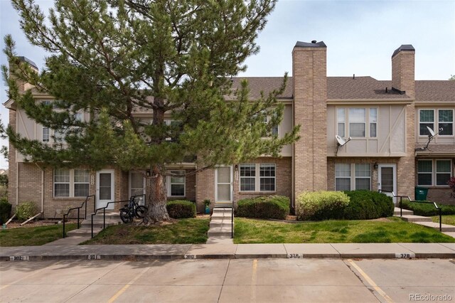3098 W 107th Pl Unit C, Westminster, CO 80031 - view of front of property with uncovered parking, brick siding, and a chimney