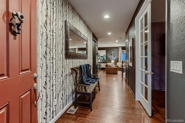 hallway with hardwood / wood-style flooring and french doors