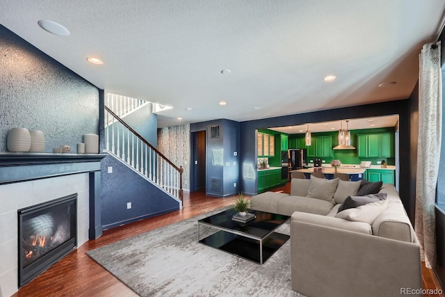 living room featuring dark hardwood / wood-style floors, a textured ceiling, and a fireplace