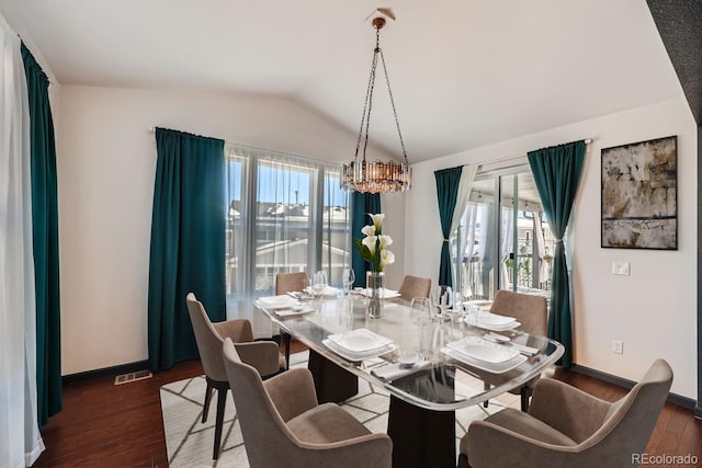 dining room featuring dark hardwood / wood-style floors, vaulted ceiling, and a wealth of natural light