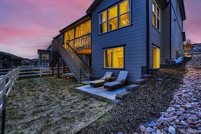 back house at dusk featuring a patio area