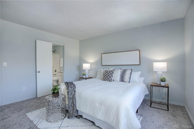 bedroom featuring ensuite bath, a textured ceiling, and light colored carpet