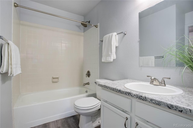 full bathroom with hardwood / wood-style floors, bathing tub / shower combination, vanity, and toilet