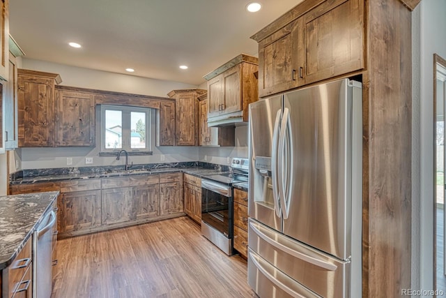 806 S St, Silver Cliff, CO 81252 - kitchen featuring appliances with stainless steel finishes, a sink, dark stone countertops, light wood finished floors, and under cabinet range hood