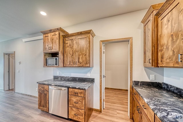 806 S St, Silver Cliff, CO 81252 - kitchen featuring appliances with stainless steel finishes, light wood-style floors, dark stone counters, and brown cabinets