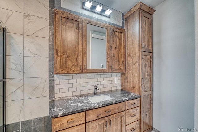 806 S St, Silver Cliff, CO 81252 - kitchen featuring a sink, dark stone counters, backsplash, and brown cabinets