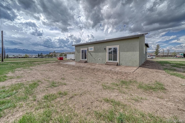 806 S St, Silver Cliff, CO 81252 - back of house with entry steps, stucco siding, and a patio area