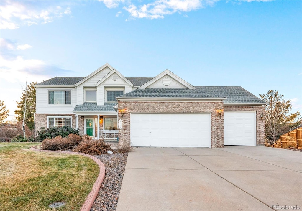 view of front of home with a porch, a garage, and a front lawn