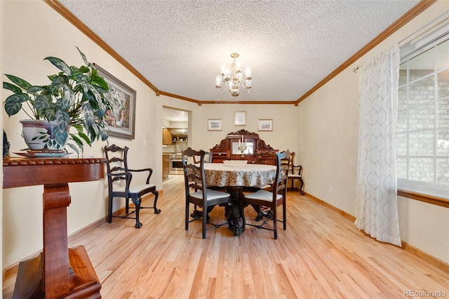 dining room with ornamental molding, light hardwood / wood-style floors, and a notable chandelier