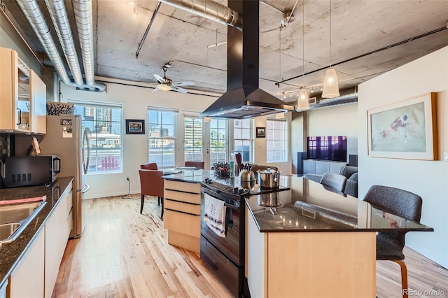 kitchen featuring hanging light fixtures, island exhaust hood, a breakfast bar area, black range with electric cooktop, and light hardwood / wood-style floors