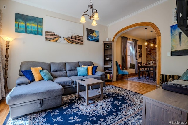 433 Fox St, Denver, CO 80204 - living room featuring wood finished floors, crown molding, arched walkways, a chandelier, and baseboards