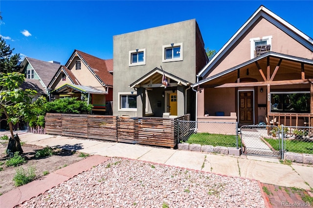 433 Fox St, Denver, CO 80204 - view of front of property featuring a gate, covered porch, a fenced front yard, and stucco siding