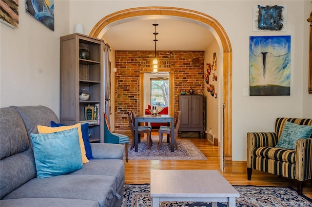 433 Fox St, Denver, CO 80204 - living room with wood finished floors, arched walkways, and brick wall