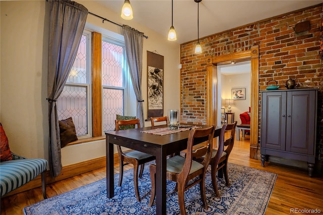 433 Fox St, Denver, CO 80204 - dining room featuring light wood-type flooring, baseboards, and brick wall