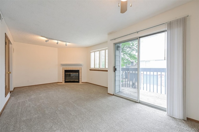 1301 S Cathay Ct Unit 104, Aurora, CO 80017 - unfurnished living room with carpet flooring, a fireplace, a textured ceiling, a ceiling fan, and baseboards