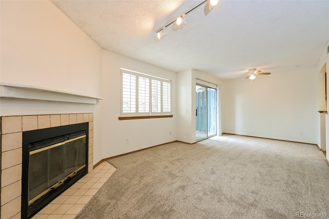 1301 S Cathay Ct Unit 104, Aurora, CO 80017 - unfurnished living room with a fireplace, a ceiling fan, carpet, a textured ceiling, and baseboards