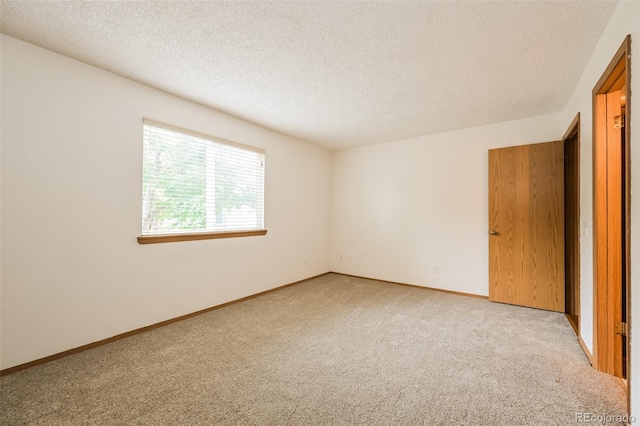 1301 S Cathay Ct Unit 104, Aurora, CO 80017 - spare room featuring carpet floors, a textured ceiling, and baseboards