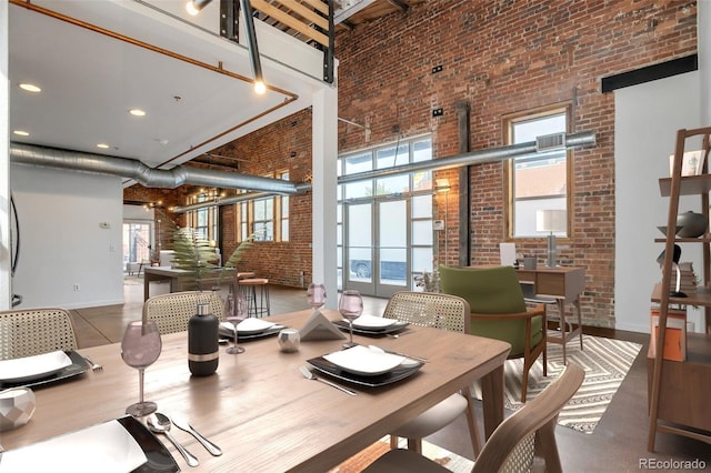 3033 Blake St Unit 121, Denver, CO 80205 - dining space with a towering ceiling and brick wall