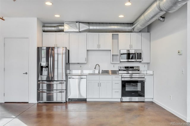 3033 Blake St Unit 121, Denver, CO 80205 - kitchen featuring stainless steel appliances, concrete flooring, recessed lighting, white cabinetry, and stainless steel counters