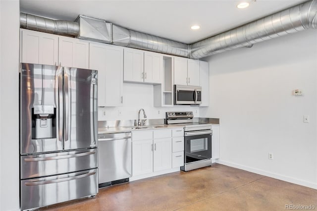 3033 Blake St Unit 121, Denver, CO 80205 - kitchen featuring appliances with stainless steel finishes, stainless steel counters, white cabinets, recessed lighting, and concrete floors