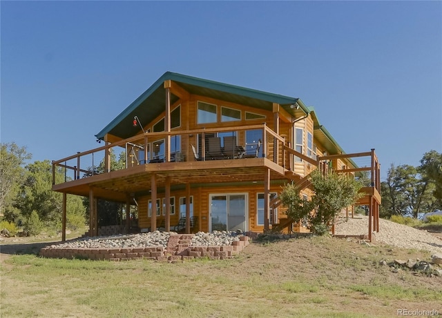 back of house featuring a balcony and a lawn