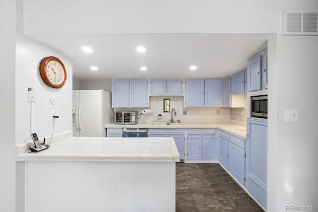 7172 S Vine Cir, Centennial, CO 80122 - kitchen with appliances with stainless steel finishes, a peninsula, recessed lighting, blue cabinetry, and a sink