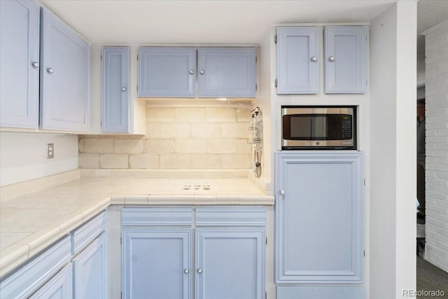 7172 S Vine Cir, Centennial, CO 80122 - kitchen featuring stainless steel microwave, backsplash, and tile countertops