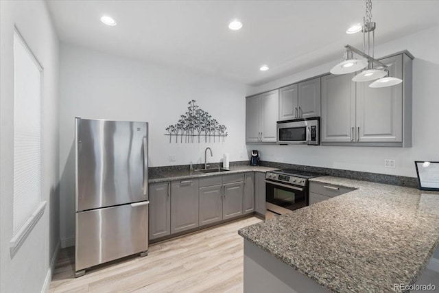 7172 S Vine Cir, Centennial, CO 80122 - kitchen featuring stainless steel appliances, gray cabinetry, a sink, light wood-style floors, and dark stone counters
