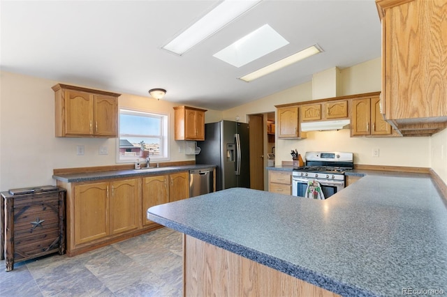 kitchen featuring sink, vaulted ceiling with skylight, and appliances with stainless steel finishes