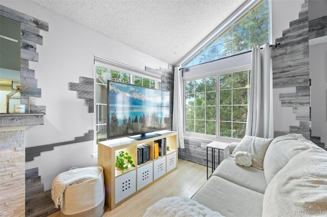 13824 E Lehigh Ave Unit B, Aurora, CO 80014 - living room featuring a fireplace, a textured ceiling, wood finished floors, and lofted ceiling