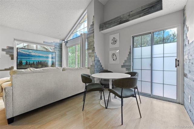 13824 E Lehigh Ave Unit B, Aurora, CO 80014 - dining space with stairway, light wood-type flooring, a textured ceiling, and high vaulted ceiling