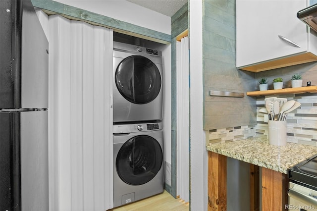 13824 E Lehigh Ave Unit B, Aurora, CO 80014 - laundry area with stacked washer / drying machine and wood finished floors