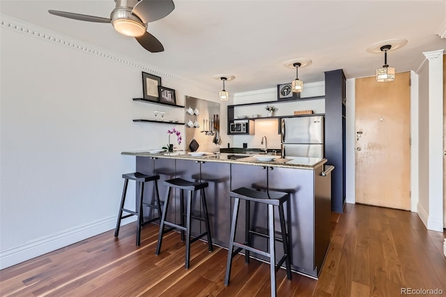 1050 N Corona St Unit 308, Denver, CO 80218 - kitchen with appliances with stainless steel finishes, open shelves, a sink, a peninsula, and crown molding