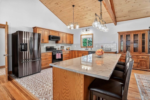 1539 Bluebird Dr, Bailey, CO 80421 - kitchen featuring stainless steel fridge with ice dispenser, range with gas cooktop, wood ceiling, brown cabinetry, and light wood finished floors