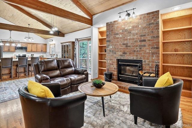 1539 Bluebird Dr, Bailey, CO 80421 - living room featuring a wooden ceiling with exposed beams, wood finished floors, a brick fireplace, high vaulted ceiling, and built in features