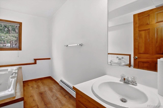1539 Bluebird Dr, Bailey, CO 80421 - bathroom with a baseboard radiator, vanity, wood finished floors, and a bathtub