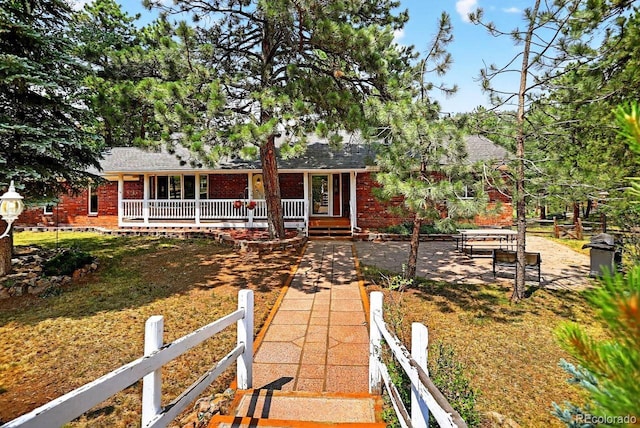 1539 Bluebird Dr, Bailey, CO 80421 - ranch-style home featuring brick siding, covered porch, a shingled roof, and a patio