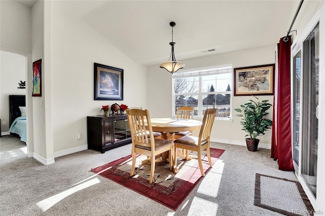 dining area featuring lofted ceiling, visible vents, light carpet, and baseboards