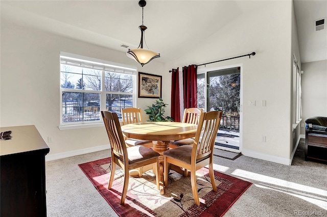 dining room featuring a healthy amount of sunlight, baseboards, and vaulted ceiling