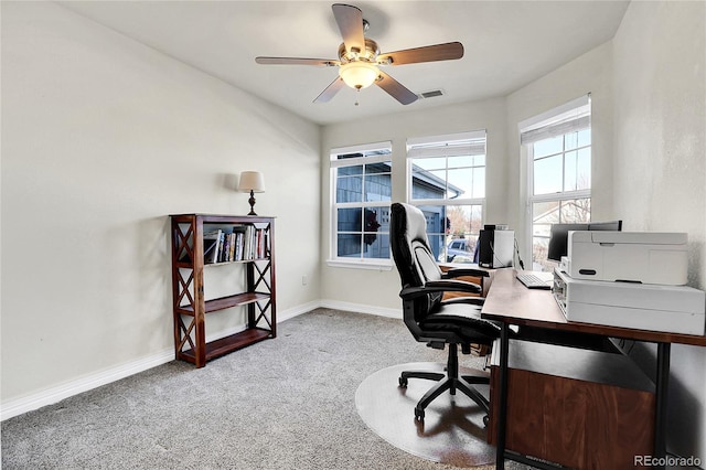 carpeted home office featuring baseboards, visible vents, and ceiling fan