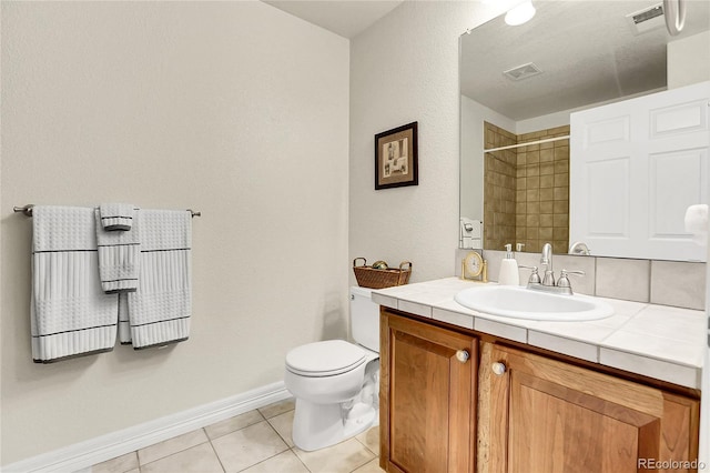 bathroom featuring toilet, visible vents, a tile shower, and tile patterned floors