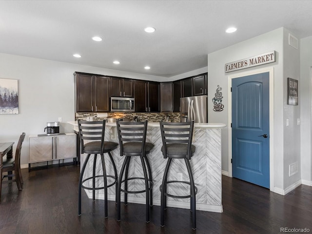 6832 Sequoia St, Frederick, CO 80530 - kitchen featuring stainless steel appliances, backsplash, dark wood finished floors, recessed lighting, and dark brown cabinets