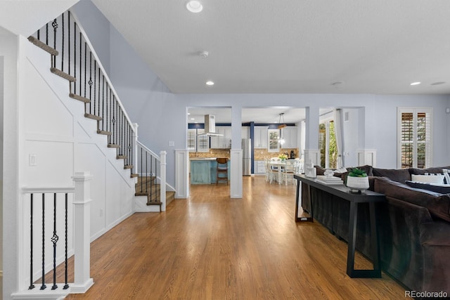 living area featuring recessed lighting, stairs, and wood finished floors