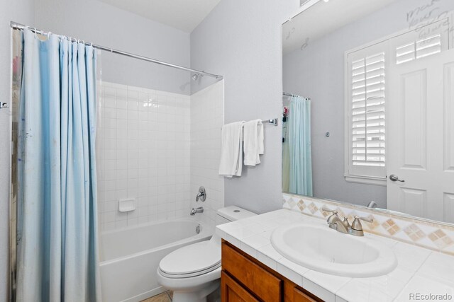 bathroom featuring vanity, shower / bath combo, and toilet