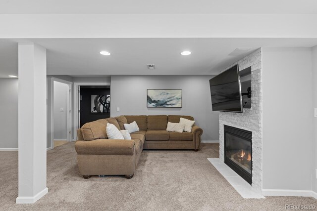 living room featuring carpet floors, recessed lighting, baseboards, and a stone fireplace