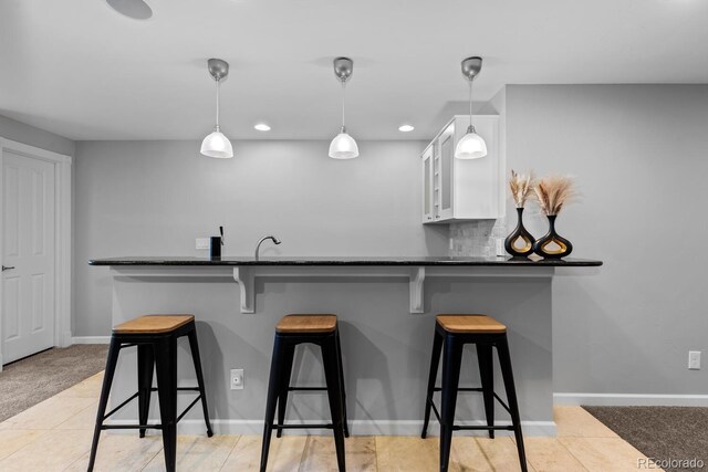 bar featuring baseboards, hanging light fixtures, and decorative backsplash