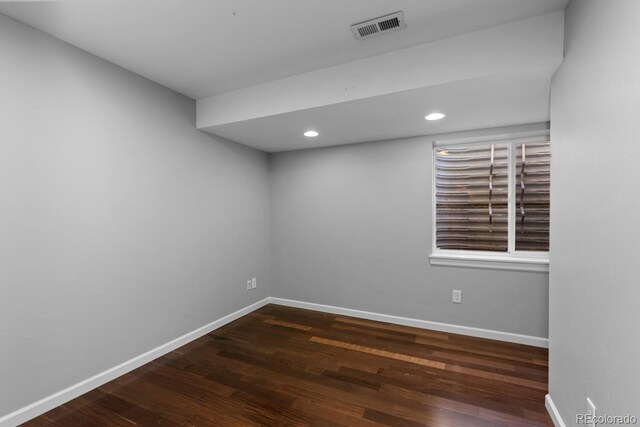 unfurnished room with baseboards, wood finished floors, and visible vents